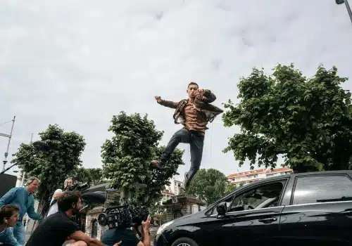 Les Orphelins 2 - Inoxy Films Les Orphelins Dali Benssalah saute par dessus une voiture, avec un plan des réalisateurs qui films la scène par en dessous - Inoxy Films