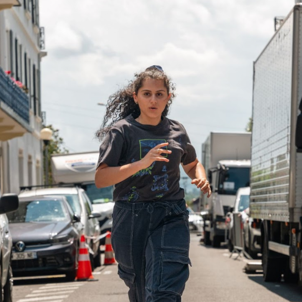 Sonia Faidi as Leïla in Les orphelins produced by Inoxy films A curly-haired woman running in the street - Sonia Faidi as Leïla in Les orphelins produced by Inoxy films